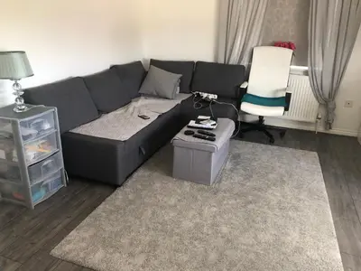 a living room with a gray couch and a chair at Basildon, private room in a flat in Basildon