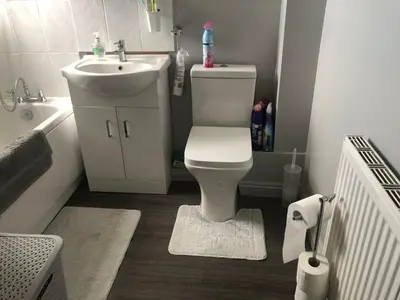 a bathroom with a white toilet and a sink at Basildon, private room in a flat in Basildon