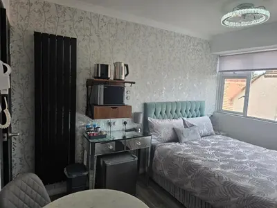 a small bedroom with a bed and a table at Martello Bay Hotel in Clacton-on-Sea