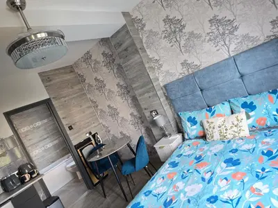 a bedroom with a blue bed and a table at Martello Bay Hotel in Clacton-on-Sea