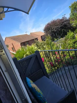 a balcony with a chair on a fence with flowers at Martello Bay Hotel in Clacton-on-Sea