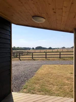 a barn with a view of a field and a fence at Nightjar Lodge - Adults Only in Lackford