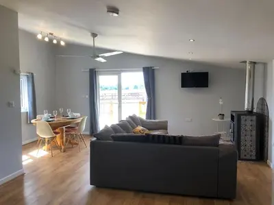 a living room with a couch and a table at Nightingale Lodge - Adults Only in Lackford