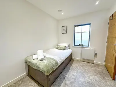a small bedroom with a bed and a window at Gwydir Street Stays in Cambridge