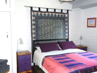 a bedroom with a bed with a red and blue blanket at Orchard View in Bungay