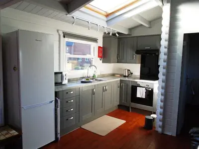 a kitchen with gray cabinets and a white refrigerator at Orchard View in Bungay