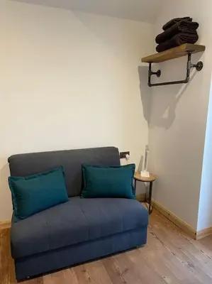 a blue couch in a living room with a table at The old wash house in Denver