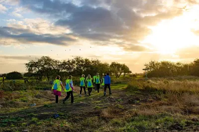 a group of people walking in a field at sunset at Glass House Retreat in Puddle Dock