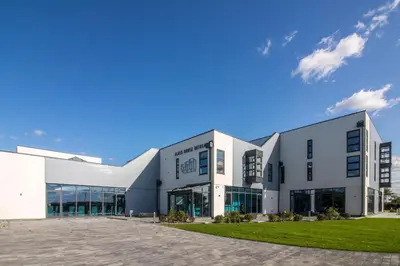a large white building with a parking lot at Glass House Retreat in Puddle Dock