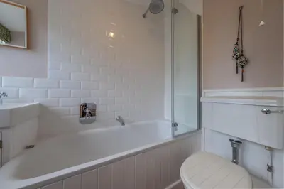 a bathroom with a tub and a toilet and a sink at Brimming with Medieval charm - Weavers Cottage in Lavenham