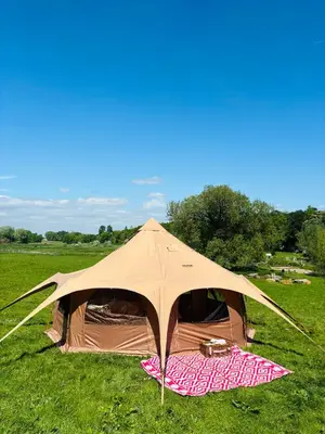 a tent in the middle of a field at HERTFORD Farm yurt Tent Camping fire pit bbq pet friendly in Hertford