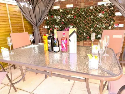 a table with wine bottles and glasses on it at Colchester City Luxury With Free Parking and 5 G WIFI in Colchester