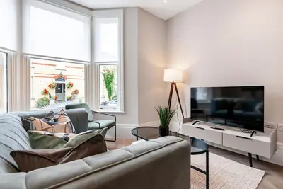 a living room with a couch and a flat screen tv at Tailored Stays - Central Cambridge, Warkworth Lodge in Cambridge