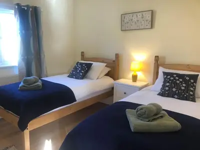 a bedroom with two beds with towels on them at Wagtail Lodge in Lackford