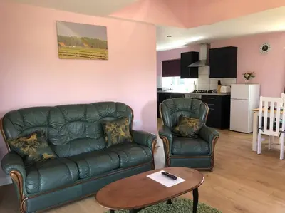 a living room with a couch and two chairs and a table at Wagtail Lodge in Lackford