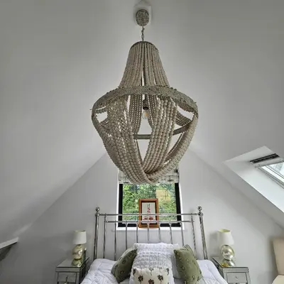 a chandelier hangs above a bed in a bedroom at Field View in Elmswell