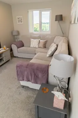 a living room with a couch and a table at The Retreat- amazing scenic views of the Essex countryside! in Salcott