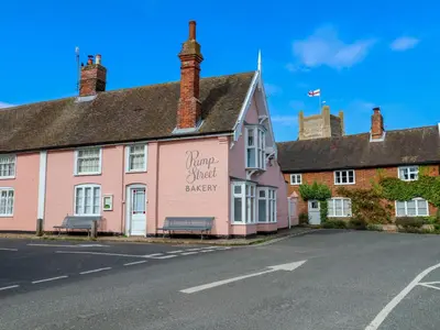 a pink building with a sign for a church energy at 1 Market Hill in Woodbridge