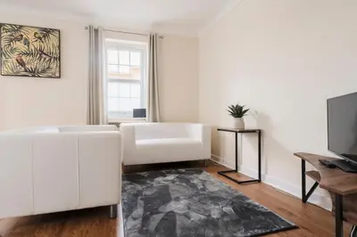 a living room with a white couch and a television at Ely Stays Flat 1 in Ely