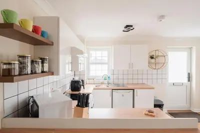 a kitchen with white cabinets and a counter top at Ely Stays Flat 1 in Ely