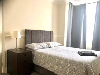a bedroom with a bed with a dresser and a window at Ac Lounge 36 Room A in Rochford