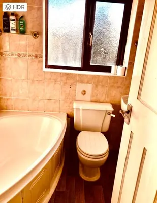 a bathroom with a toilet and a tub and a window at Ac Lounge 36 Room A in Rochford