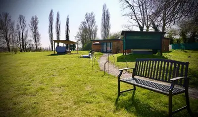 a park with a bench in a grass field at Rocklands Retreat in Rockland Saint Peter