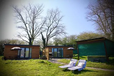 a couple of chairs sitting outside of a tiny house at Rocklands Retreat in Rockland Saint Peter
