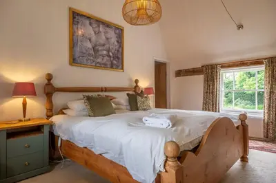a bedroom with a large bed and a window at Cutbush Farm House in Hingham
