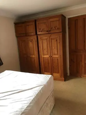 a bedroom with wooden cabinets and a white bed at Lawrence House in Cambridge