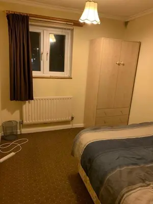 a bedroom with a bed and a dresser and a window at Lawrence House in Cambridge