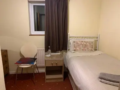 a bedroom with a bed and a chair and a window at Lawrence House in Cambridge