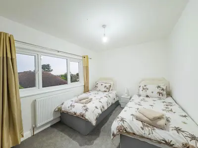 a bedroom with two beds and a window at Southend Retreat KING SUITE Luxury stay with parking in Southend-on-Sea