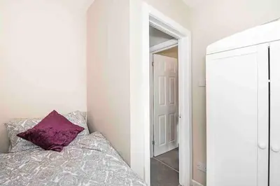 a bedroom with a purple pillow on a bed and a mirror at By Buildersbeds - Colne House 4 bedrooms in Harold Wood