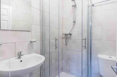 a bathroom with a shower and a sink and a toilet at By Buildersbeds - Colne House 4 bedrooms in Harold Wood