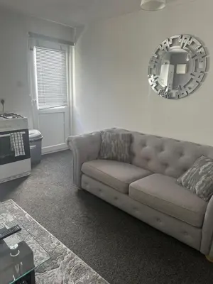 a living room with a couch and a mirror at Cosy 1 Bedroom Bungalow Between Basildon & Wickford in Nevendon