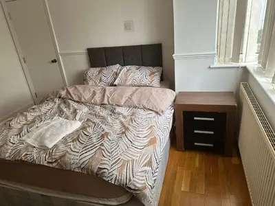 an unmade bed in a small bedroom with a table at At Apex House in Horndon on the Hill