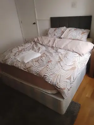 an unmade bed in a room with at At Apex House in Horndon on the Hill