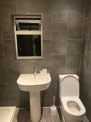 a bathroom with a sink and a toilet and a mirror at At Apex house in Horndon on the Hill