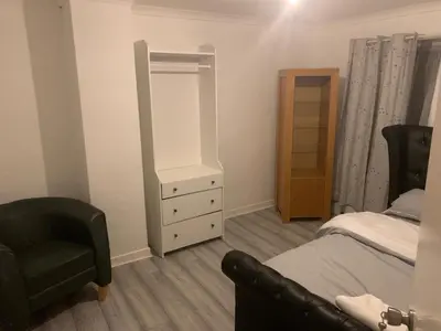 a bedroom with a bed and a dresser and a chair at At Apex house in Horndon on the Hill