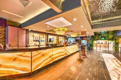 a restaurant with a bar in the middle of a room at Palms Hotel & Retreat By Palette London Romford in Hornchurch