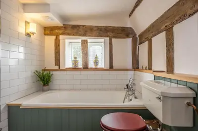 a bathroom with a bath tub and a toilet at Cutbush Farm House 6 in Hingham