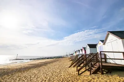 a row of beach houses on a sandy beach at 3 Bed in Felixstowe oc-p29748 in Felixstowe