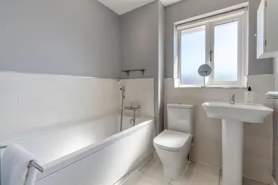 a white bathroom with a tub and a sink and a toilet at 3 Bed in Felixstowe oc-p29748 in Felixstowe