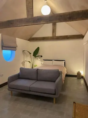 a living room with a couch and a bed at Cambridgeshire Wabi-sabi in Barrington