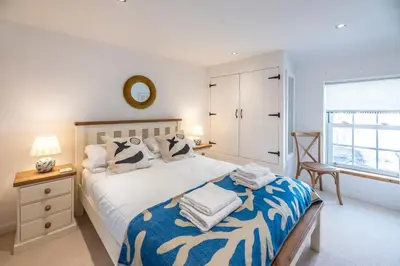 a bedroom with a large bed and a window at Beachcomber, Aldeburgh in Aldeburgh