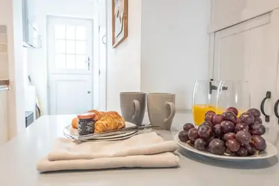a table with a plate of fruit and a glass of orange juice at Beachcomber, Aldeburgh in Aldeburgh