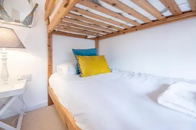 a bedroom with a bed with a yellow pillow on it at Beachcomber, Aldeburgh in Aldeburgh