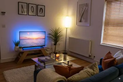 a living room with a couch and a table with a television at The Falcon's Nest - Central in Bury Saint Edmunds