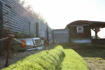 a car parked in a yard next to a building at Little Lodge Glamping in Halesworth